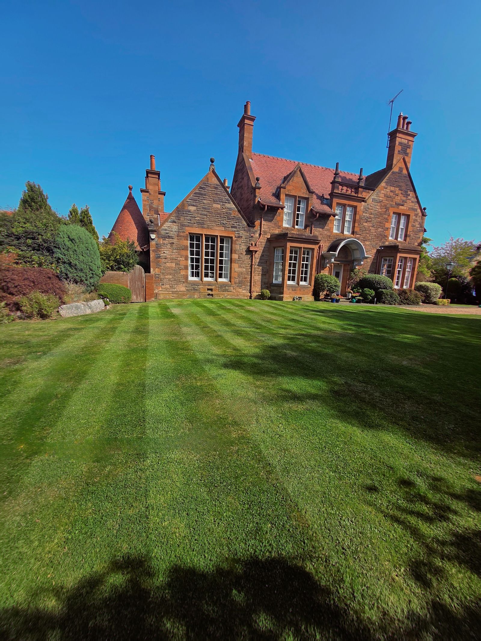 Striped lawn in front of a red sandstone house in Edinburgh